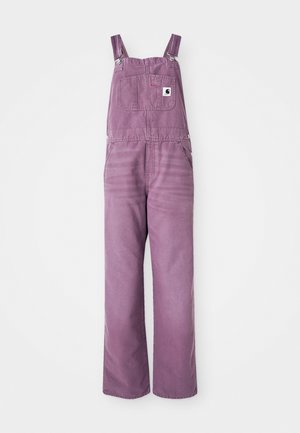 Salopette in denim viola con bretelle regolabili, tasca frontale e gambe larghe. Il materiale presenta una leggera texture; gli accessori in metallo sono di colore argento.