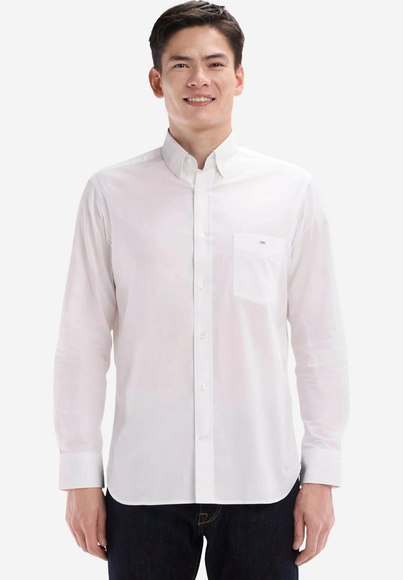 Chemise blanche à boutons avec manches longues, col classique, poche poitrine unique et texture lisse. Présente une broderie de marque sur la poche.