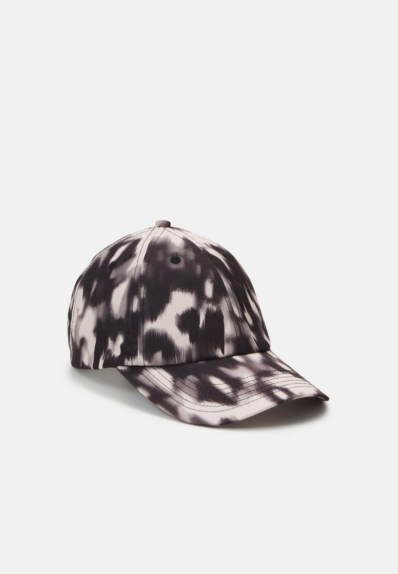 Casquette de baseball tie-dye noire et blanche avec six panneaux, trous de ventilation et visière incurvée sur un fond clair uni.