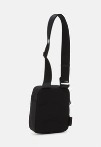 Borsa a tracolla nera con un frontale in rete testurizzata, tracolla regolabile e chiusura con zip. Forma quadrata compatta con dettagli a forma geometrica.