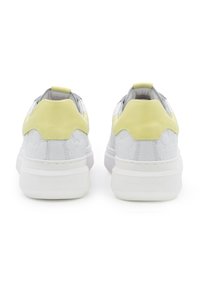 Sneaker bianche con un motivo testurizzato, dettagli giallo chiaro sul tallone e una spessa suola bianca con branding impresso sul retro.