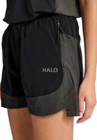 Nærbillede af sorte og mørkegrå atletikshorts med elastisk linning, lille lynlåslomme og "HALO"-logo på venstre lår.
