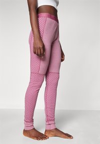Rózsaszín, mintás leggings, csíkok és geometrikus formák keverékével, bordás derékpánttal és szorosan illeszkedő bokákkal.
