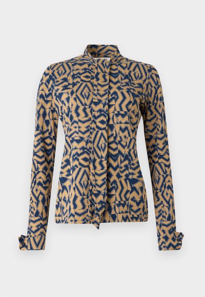 Patterned jacket in navy blue and beige, featuring geometric designs. Long sleeves with buttoned cuffs, mandarin collar, and front tie closure.