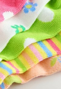 Tejidos de punto de colores vivos que incluyen rosa, verde, blanco con flores y patrones a rayas en azul, amarillo y rosa.