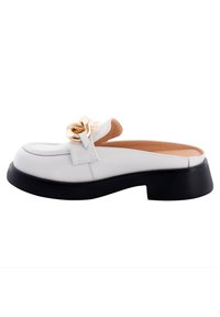 Scarpa slip-on in pelle verniciata bianca con piattaforma nera, dotata di un accento a catena dorata sulla parte anteriore e una fodera interna liscia.