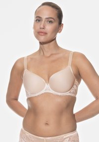 Beige push-up rintaliivi, jossa on sileät mikrofiberkuppit ja pitsiyksityiskohta. Varustettu säädettävillä olkaimilla ja hakaskiinnityksellä selässä.