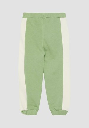Groene joggingbroek met witte zijpanelen en elastische boorden, plat neergelegd op een neutrale achtergrond.