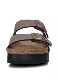 Sandali con plantare in sughero marrone, dotati di due cinturini regolabili, fibbie in tonalità rame e una suola in gomma nera texture.