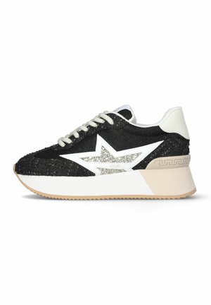 Zapatilla en blanco y negro con detalle de estrella brillante, suela plataforma beige y cordones blancos, mostrada de perfil sobre fondo blanco.