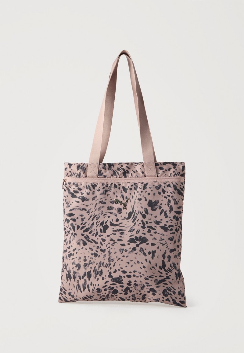 Sac fourre-tout rose clair avec longues anses et motif abstrait à pois noirs, avec un petit logo kangourou métallique à l'avant.