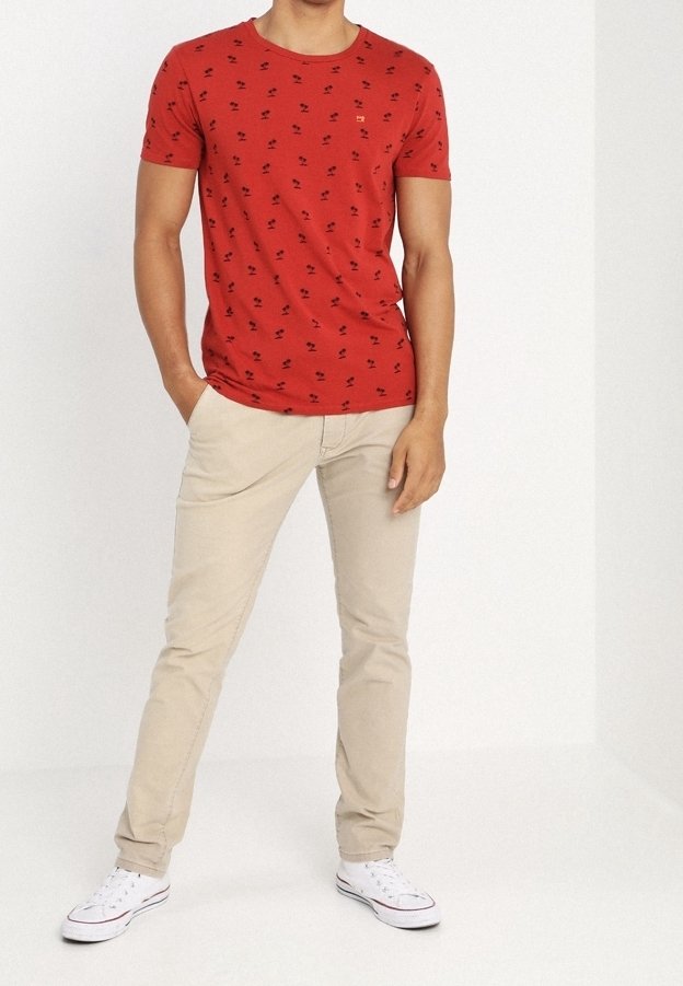 Rød kortærmet T-shirt med små sorte mønstre, parret med beige slim-fit bukser og hvide sneakers. Enkel rund halsudskæring, afslappet stil.