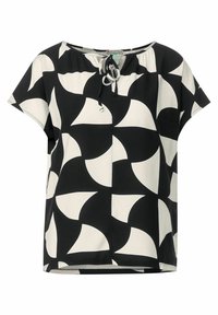 Blouse à motifs noir et blanc avec des manches courtes, un col rond et un détail à cordon au devant. Fabriquée en tissu léger.