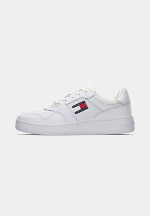 White athletic sneaker with a smooth leather upper, round toe, flat laces, and a logo patch in red, white, and blue. Textured rubber sole.