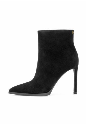 Czarne zamszowe botki za kostkę z ostrym czubkiem i wysokim obcasem w stylu stiletto. Charakteryzują się minimalistycznym designem i subtelnym akcentem w postaci złotego logo.
