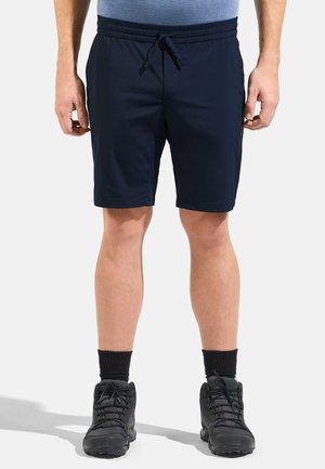 Navy blue elastic shorts with drawstring, two side pockets, and a lightweight, smooth texture, paired with black hiking boots and black socks.