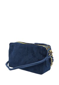 Sac bandoulière en velours côtelé bleu marine avec une fermeture éclair en or et des accessoires accentués. Forme rectangulaire avec un design texturé et une bandoulière réglable.