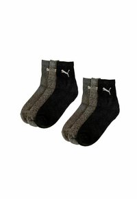 Zwei Sets mit jeweils drei Paar Puma Knöchelsocken in Schwarz und Dunkelgrau, nebeneinander auf einem weißen Hintergrund präsentiert.