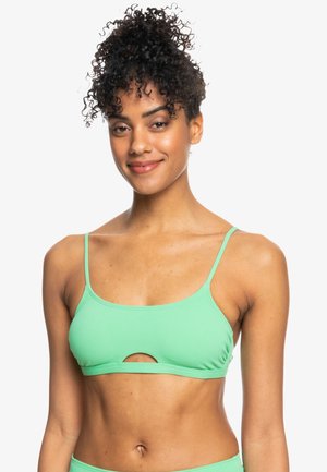 Top bikini verde menta con spalline sottili, forma rettangolare e dettaglio di taglio frontale. Realizzato in tessuto testurizzato, progettato per l'uso in costume da bagno.