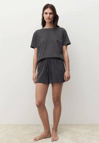 Sivi pamučni kratki top s kratkim rukavima i odgovarajuće šortseve s elastičnom trakom. Glatka tekstura, opušteni kroj, bez vidljivih uzoraka ili hardvera.