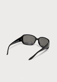 Schwarze Sonnenbrille mit rechteckigem Rahmen und dunklen Gläsern. Elegante, glänzende Oberfläche und geschwungene Bügel. CE-Kennzeichnung sichtbar an der Innenseite des Bügels.