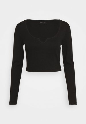 Schwarzes, langärmeliges, kurz geschnittenes Oberteil mit rundem Ausschnitt und kleinem V-Einschnitt, gerippte Struktur und EVEN&ODD-Etikett innen im Kragen.