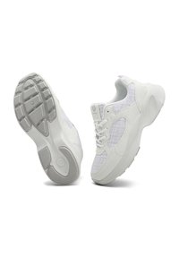 White sneakers with a textured gray fabric panel, round toe, laces, and rubber sole featuring a patterned tread for traction.