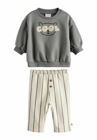 Felpa grigia con una stampa di orso e la scritta "COOL", abbinata a pantaloni corti a righe crema con vita elastica e due bottoni.