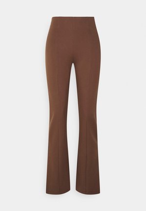 Pantalon marron taille haute ajusté avec jambes évasées et détails de couture avant sur un fond clair uni.