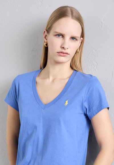 Blue cotton t-shirt with a v-neck, short sleeves, and a small yellow logo on the left chest. Smooth texture, casual design.