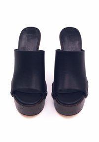 Sandali platform in pelle nera con design open toe, parte superiore curva e suole testurizzate simili al legno scuro con dettagli in metallo.