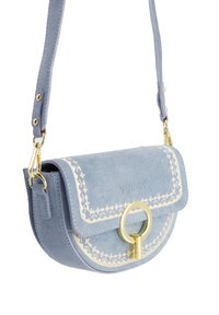Jasnoniebieska zamszowa torebka crossbody o zaokrąglonym kształcie, ze złotymi elementami i białymi haftowanymi detalami wzdłuż krawędzi klapki.