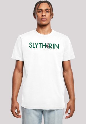 Hvit bomull T-skjorte med korte ermer, med teksten "SLYTHERIN" i grønt og grått. Standard rund halsdesign, avslappet passform.