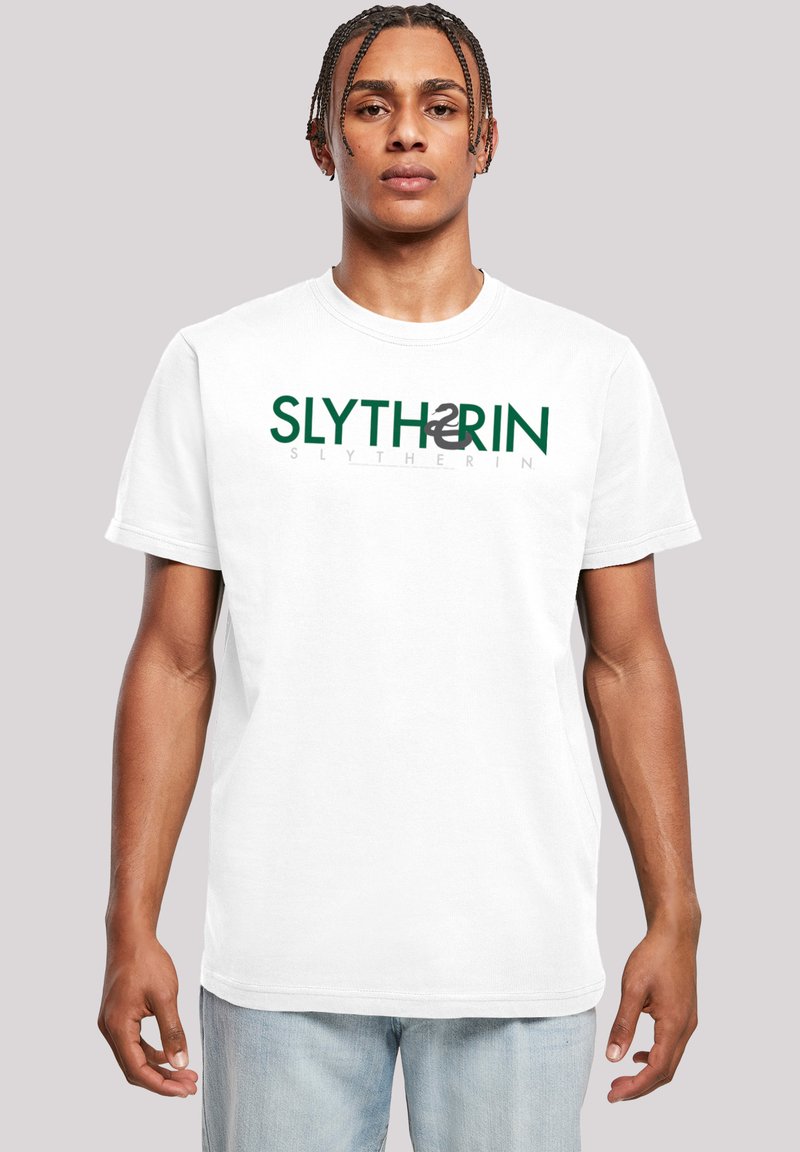 Hvit bomull T-skjorte med korte ermer, med teksten "SLYTHERIN" i grønt og grått. Standard rund halsdesign, avslappet passform.