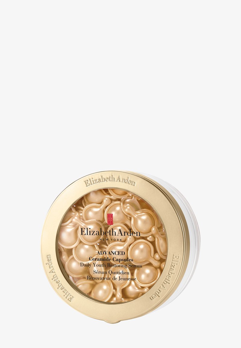 Barattolo Elizabeth Arden con capsule d'oro di ceramide per siero quotidiano rigenerante della giovinezza, coperchio trasparente e confezione con bordo dorato.