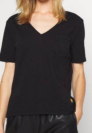 Czarny T-shirt z dekoltem w serek, wykonany z miękkiej bawełny, z krótkimi rękawami, posiadający kieszonkę na piersi oraz żółty akcent w postaci logo przy dolnym brzegu.