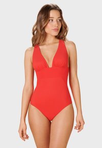Maillot de bain une pièce rouge avec un décolleté plongeant, des bretelles larges et un détail de buste froncé. Texture lisse et silhouette ajustée.