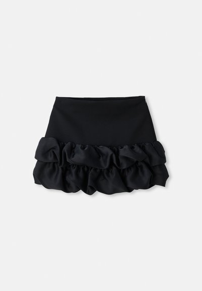 Mini-jupe noire avec un haut ajusté et trois couches de tissu froncé en bas, avec une texture lisse et des lignes épurées.