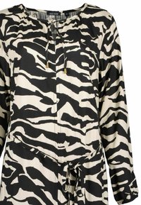 Schwarz-weißes Zebra-Muster Kleid mit langen Ärmeln, Rundhalsausschnitt, frontalen Bindedetails und einem Taillengürtel.