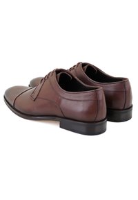 Braune Leder- dressschuhe mit glatter Oberfläche, runder Zehenform, Schnürdesign und einer flachen schwarzen Gummisohle.
