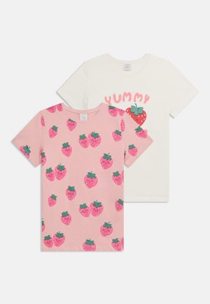 Deux t-shirts pour enfants à manches courtes, l'un rose avec des motifs de fraises souriantes, l'autre blanc avec une grande fraise et le texte "Miam".