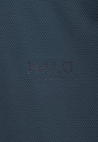 Ciemnoszara siateczkowa tkanina o teksturowanej powierzchni. Na środku znajduje się tekst "HALO" w pogrubionej czcionce z subtelnym efektem wytłoczenia.