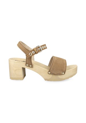 Sandale marron en daim à bout ouvert avec talon bloc en bois, bride de cheville ajustable avec boucle métallique et détails de rivets métalliques.