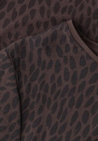 Dark brown fabric with a black irregular spotted pattern and a round neckline, likely part of a garment or clothing item.