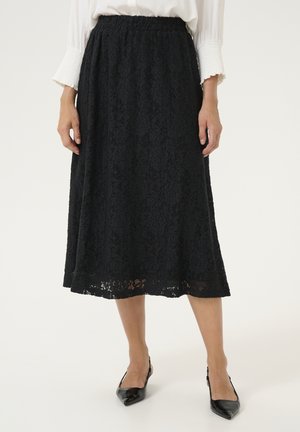 Sort blonder midi-nederdel med elastisk talje, indviklede blomster mønstre og en scalloped kant. Kombineret med spidse sorte hæle.
