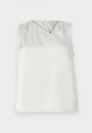 Blusa bianca senza maniche con scollo a V, sottili pieghe sulle spalle e chiusura con cerniera sul retro, mostrata su sfondo semplice.