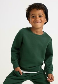 Grøn sweatshirt og matchende bukser lavet af blødt stof. Har rund hals og manchetter, med en glat tekstur og ingen synlige mønstre.