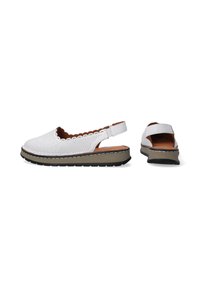 Bílé perforované slingback boty s ozdobným obloukovým okrajem, hnědou stélkou a gumovou podrážkou, které mají kontrastní vícetrakovou platformu.