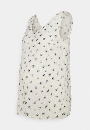 Top de maternidad floral en crema claro con flores azules y verdes, diseño de escote en v, sin mangas, tejido ligero y corte holgado.