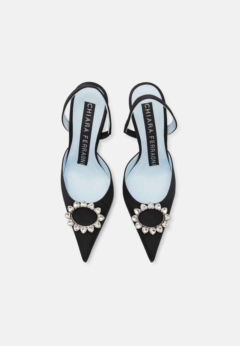 Escarpins slingback en suède noir avec bouts pointus, ornés d'un détail en laiton strass. Semelles intérieures bleu clair avec le logo de la marque.